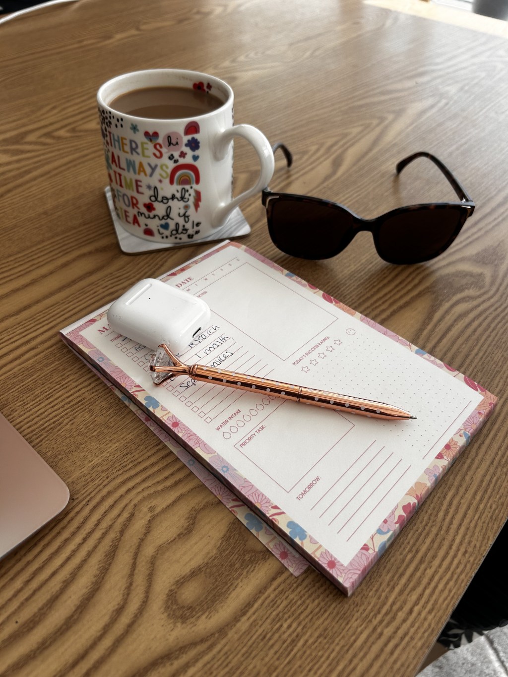 Planner, coffee and sunglasses on Sam's desk